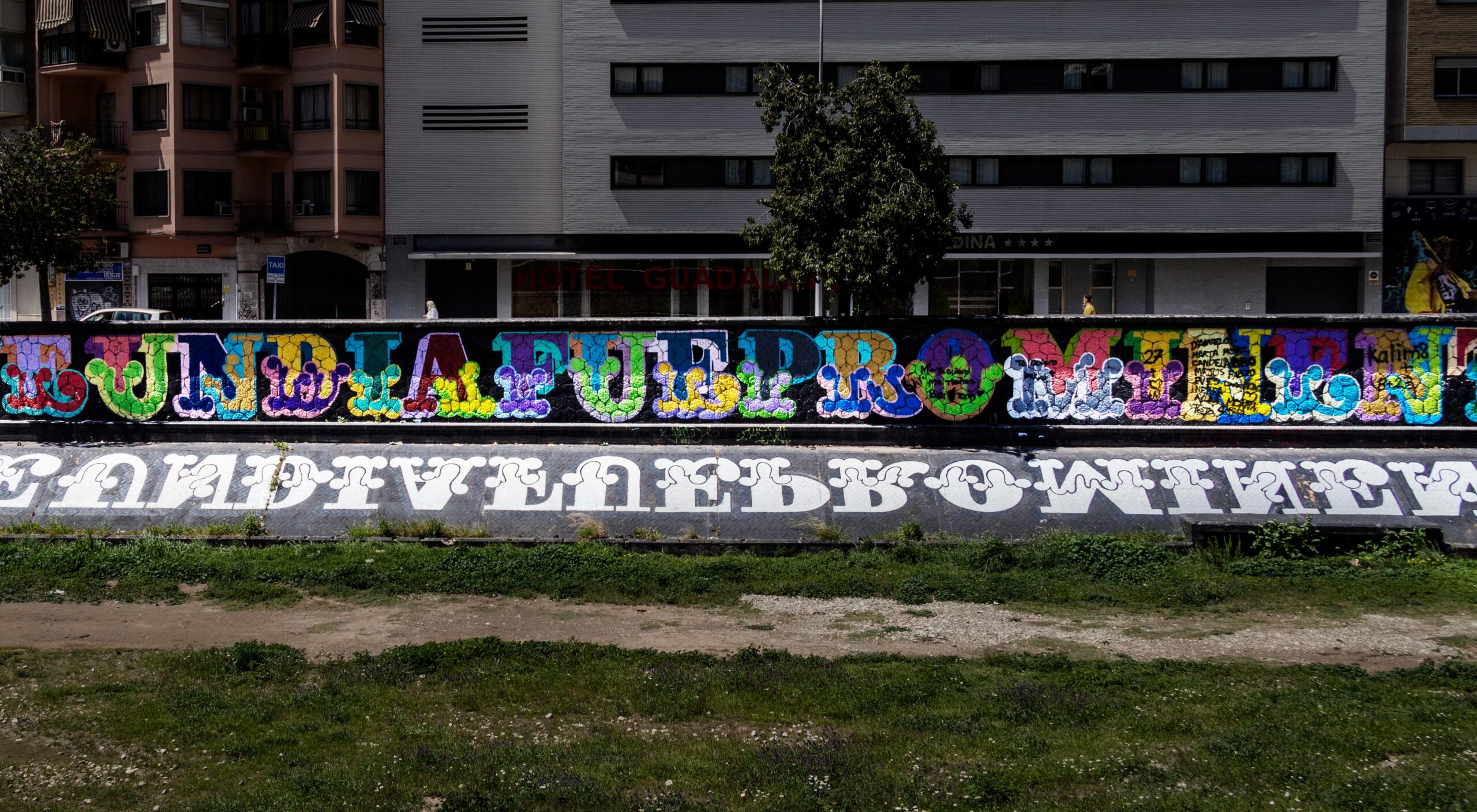 A 130-metre mural by English graphic artist Ben Eine runs along the dry riverbank to the right of the El Perchel bridge at the CAC museum.