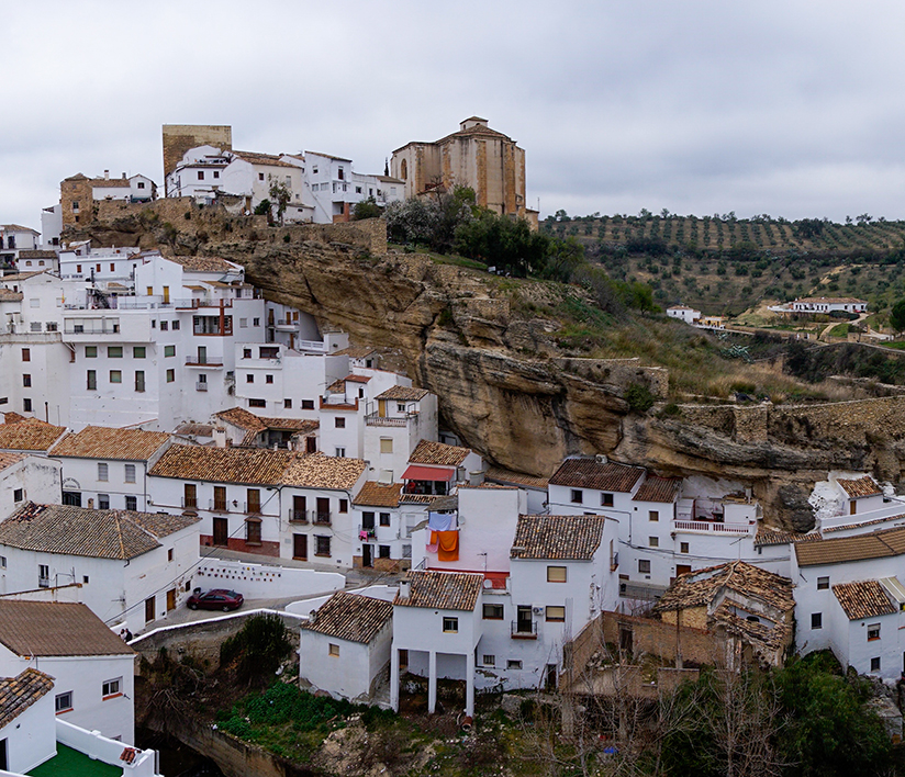 Panoramaudsigt over Setenil de las Bodegas med slottet og små kirker.